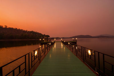 Bridge over calm lake at sunset