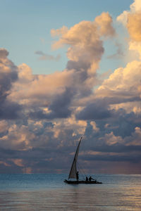 Sailboat in sea against sky during sunset