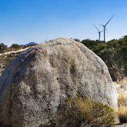 Traditional windmill on field against clear blue sky