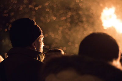 Rear view of people looking at camera