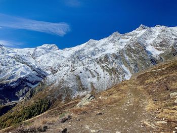 Scenic view of snowcapped mountains against blue sky