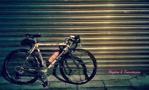 Bicycle parked against wall in city