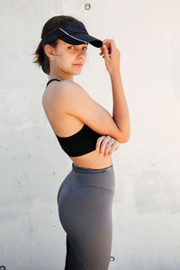 Side view of woman standing against wall