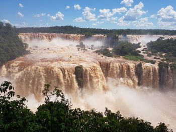 Scenic view of waterfall against sky