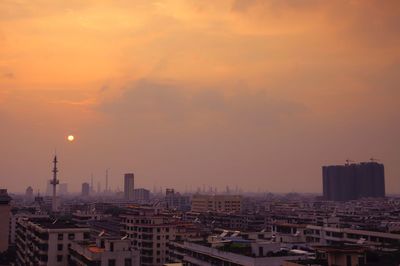 Aerial view of buildings against sky during sunset