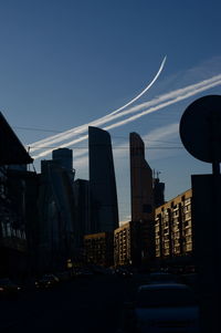 City street and buildings against sky at dusk