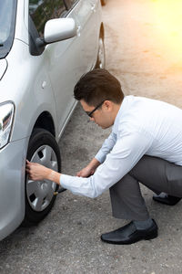 Side view of man with umbrella on car