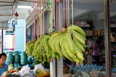 Bananas hanging outside store at market for sale