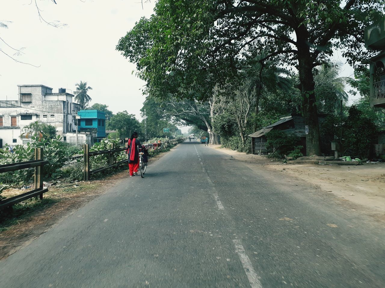 REAR VIEW OF PERSON WALKING ON ROAD