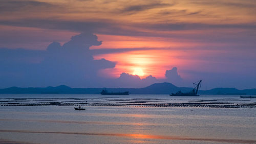 Scenic view of sea against dramatic sky during sunset