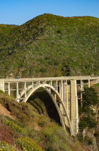 Arch bridge over mountain against sky