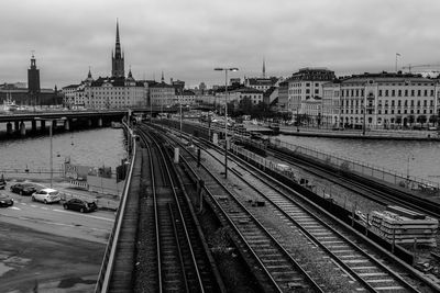 Railroad tracks in city against sky