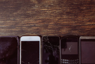 An assortment of outdated and damaged mobile phones with broken screens for repair with copy space