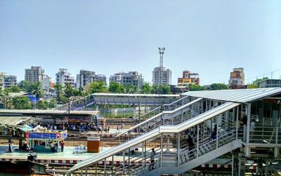 High angle view of railroad tracks by buildings against clear sky