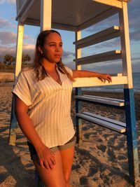 Young woman looking away while standing on beach