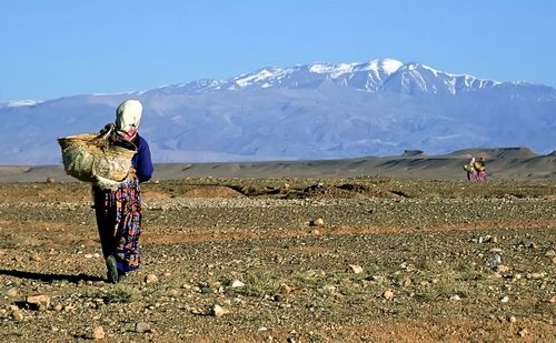 Rear view of women in authentic dresses and snowcapped mountain