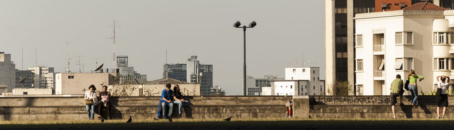 People walking on street against buildings in city