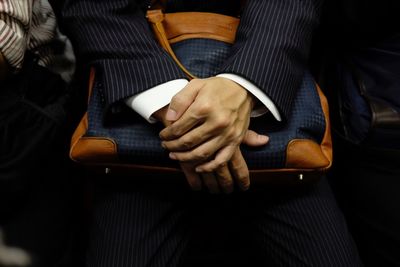 Midsection of businesswoman holding bag