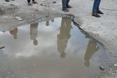 Low section of man standing on puddle