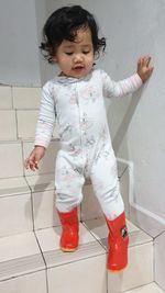 Cute girl standing on tiled floor at home