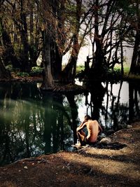 Woman sitting on tree trunk in forest