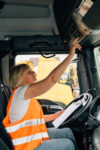 Side view of woman sitting in truck