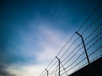 Low angle view of barbed wire against sky