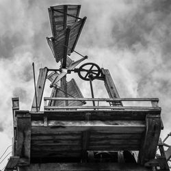 Low angle view of old machinery on field against sky