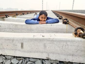Portrait of boy lying down on railroad track