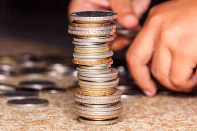 Close-up of hand counting coins by stack