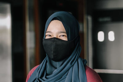 Portrait of young woman covering face