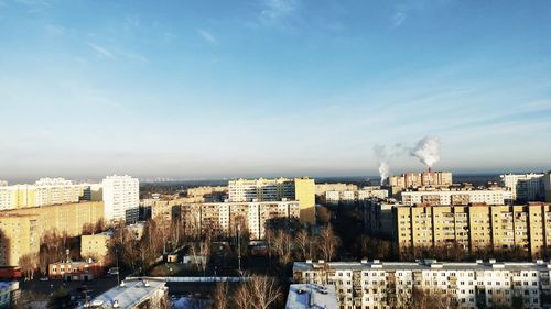 Buildings in city against cloudy sky