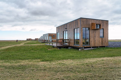 Stylish residential houses cabin with glass panoramic windows and terraces located on green grassy field in countryside of iceland in hvolsvollur