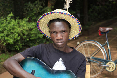 Man looking at camera holding guitar