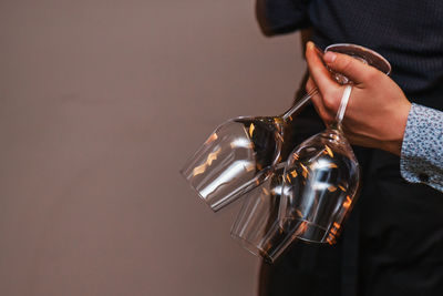 Midsection of woman holding light bulb against wall