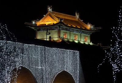 Low angle view of illuminated building against sky at night