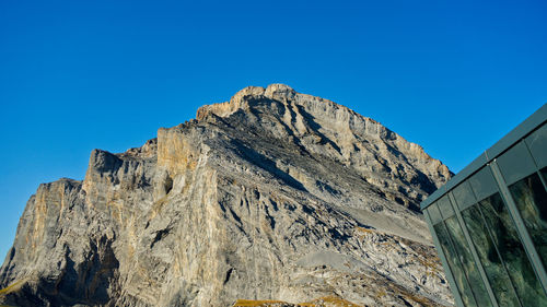 Low angle view of rock formation against clear blue sky