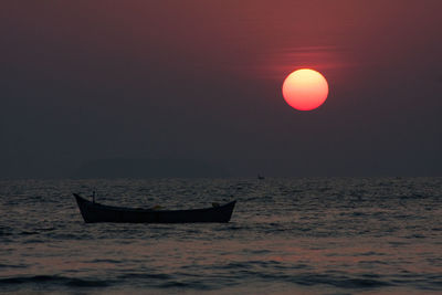 Boat in sea at sunset