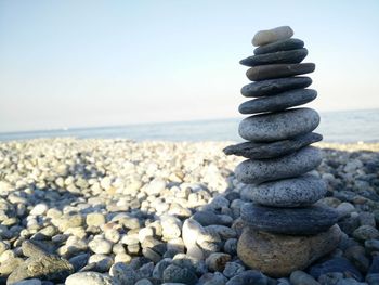 Stack of pebbles on beach against clear sky