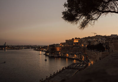 View of buildings at waterfront during sunset