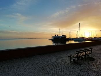 Sailboats on sea against sky at sunset