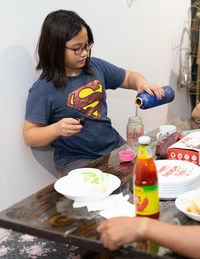 Woman looking away while sitting on table