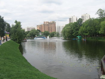 Scenic view of lake by buildings against sky