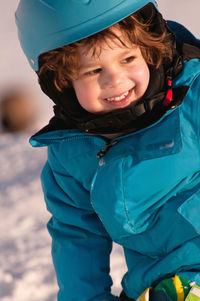 Smiling boy standing snow covered land