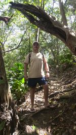 Full length rear view of man sitting in forest
