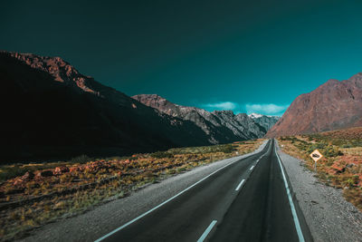 Road amidst mountains against clear sky