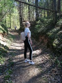 Full length rear view of man walking on footpath in forest