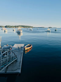 Boats in sea against clear sky