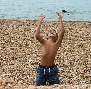 Shirtless boy playing at beach