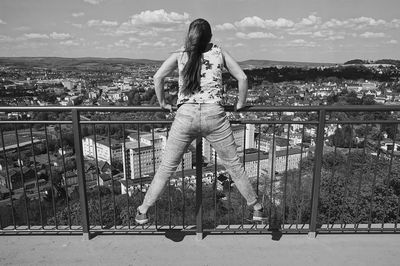 Full length of woman on railing against bridge in city